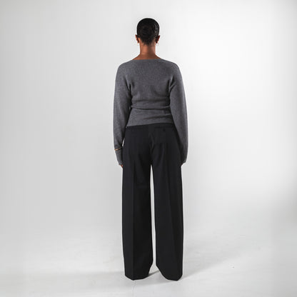 Back view of a model wearing a grey ribbed cardigan by SÎAMO SOCIÉTÉ