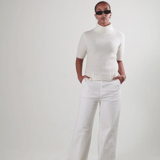 A product video showing a female in a white short sleeve turtleneck top by SÎAMO SOCIÉTÉ