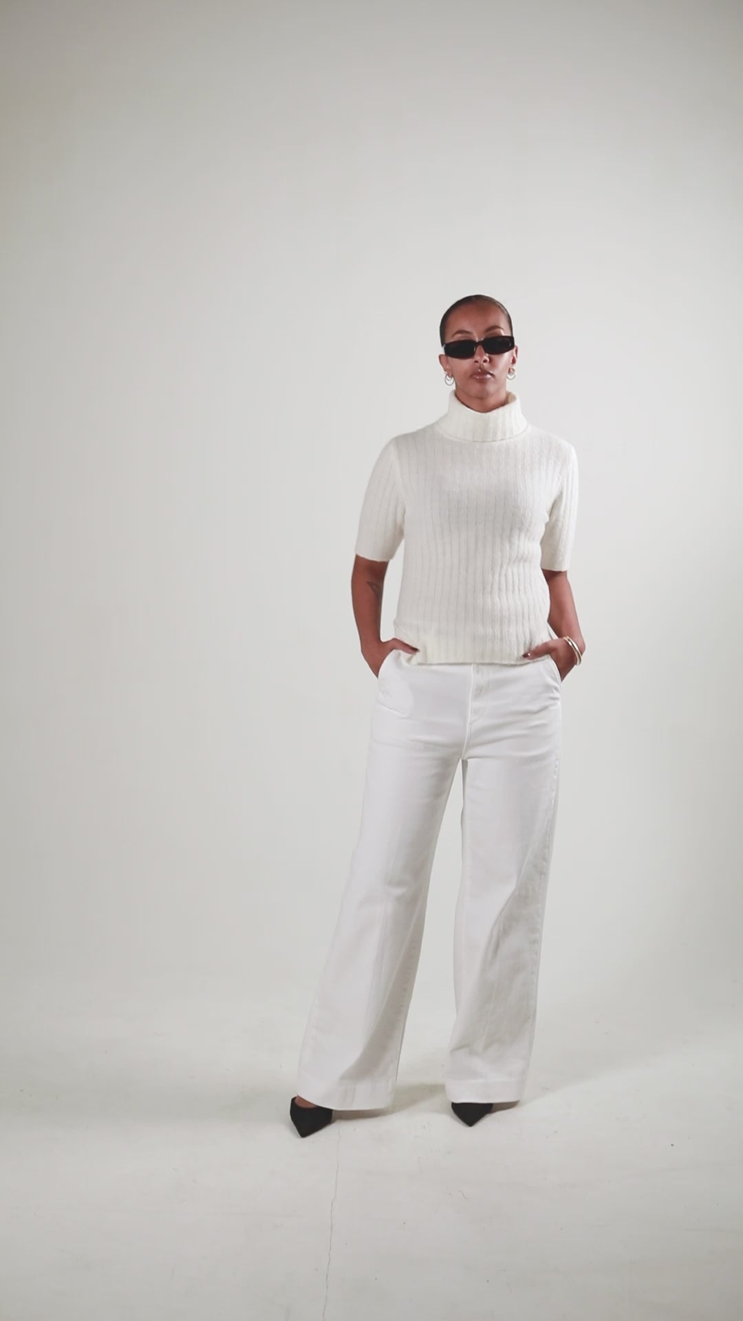 A product video showing a female in a white short sleeve turtleneck top by SÎAMO SOCIÉTÉ