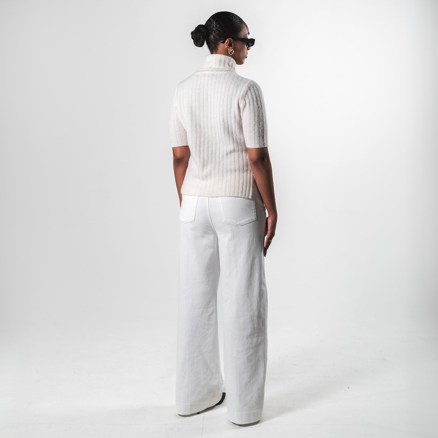 The backside of a white short sleeve turtleneck top by SÎAMO SOCIÉTÉ