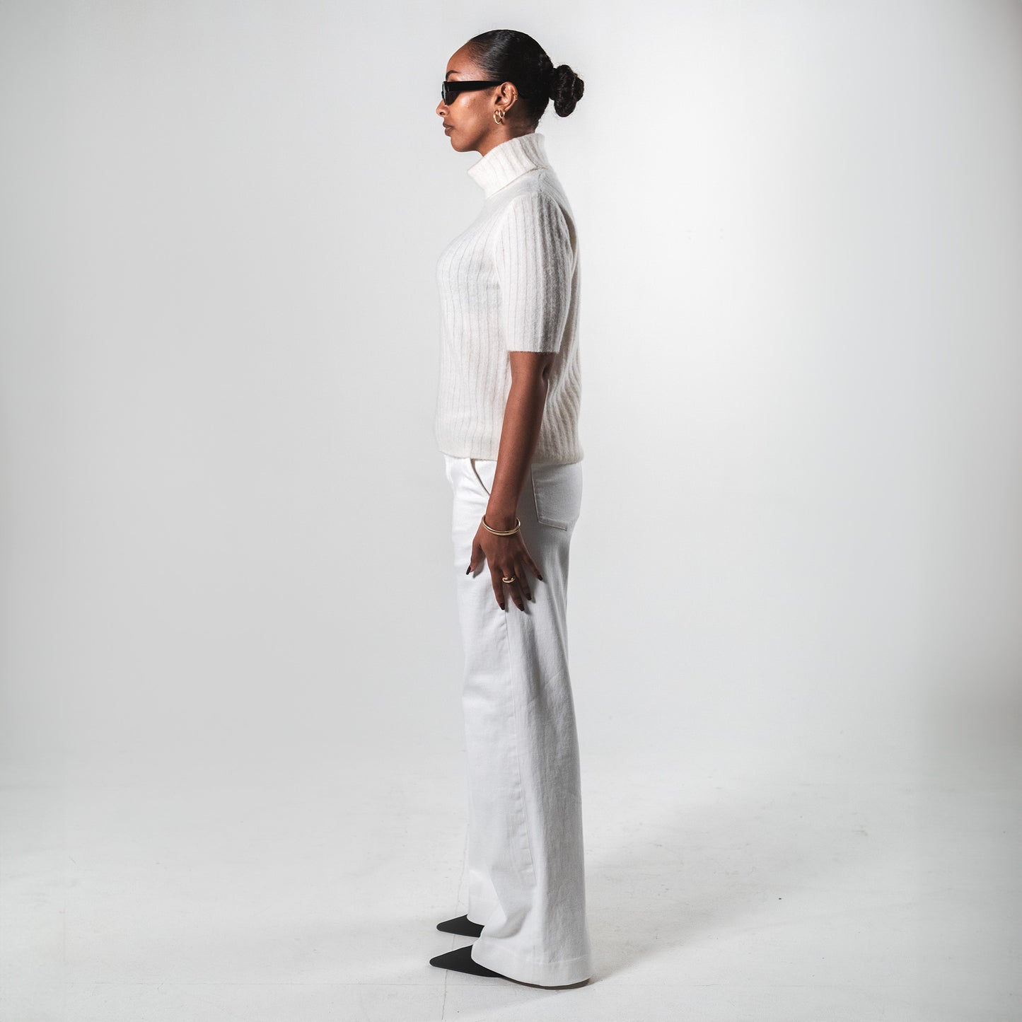 Side view of a white short sleeve turtleneck top by SÎAMO SOCIÉTÉ